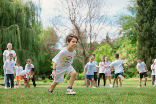 Group of children enjoying outdoor playtime in a green park during summer.